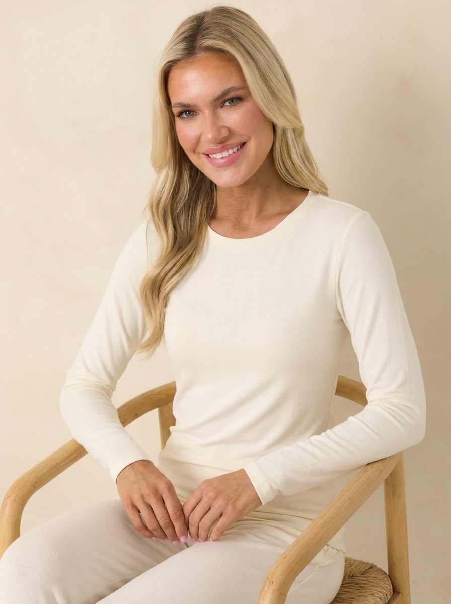 Woman wearing a cream long-sleeve shell top, lifestyle